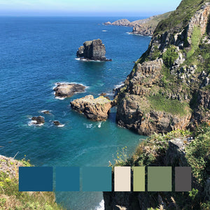 An ocean view from Sark island cliff top headland overlooking rocky coastline in vibrant blues and greens.