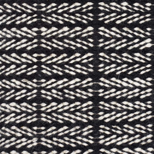 A close up look at the pattern of the Fabula Living’s Black/White Tanne Rug, which mixes natural hues to create an understated pattern - designed by Jens Landberg Schrøder. 