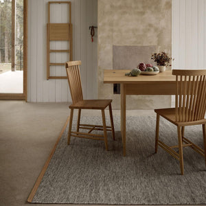 Dining room with a neutral colour scheme and wooden dining table and chairs and Design House Stockholm Bjork light grey rug