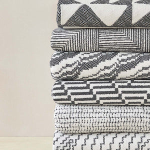 Beatrice Larkin woven merino wool blankets folded and stacked, showing geometric patterns 