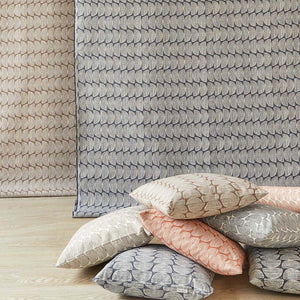 Beatrice Larkin Cresent Recycled Cotton Scatter Cushions in front of draped fabric in same pattern. The colours are nature-inspired burnt orange, forest green, truffle brown and denim blue. 