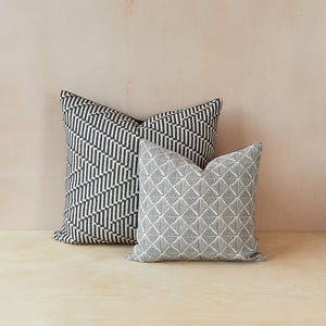Two Beatrice Larkin merino wool cushions, each featuring a different gentle monochrome geometric pattern