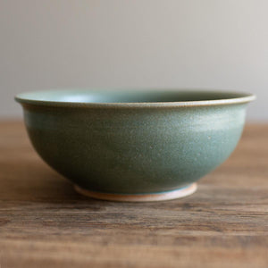 Deep ramen bowl with a softly curved rim. Hand-thrown artisan ceramic tableware handmade by Carla Murdoch in the UK. The bowl has an earthy green lichen colour glaze.