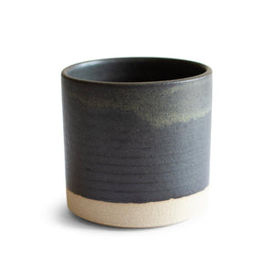 Hand-thrown artisan stoneware tumbler. Ceramic tableware handmade by Carla Murdoch in the UK. The tumbler has a dramatic black glaze with golden and khaki tones. The lower section of the tumbler outer is left unglazed.
