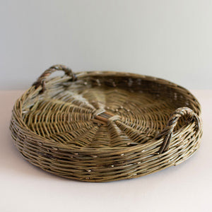 Catherine Beaumont's round Willow Tray is woven in Dicky Meadows with Brittany Green handles and is made with a traditional heritage tied underfoot base. 