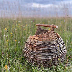 Catherine Beaumont's contemporary Waled Hunig Basket is handmade from a variety of willows. Basket in an English summer meadow.