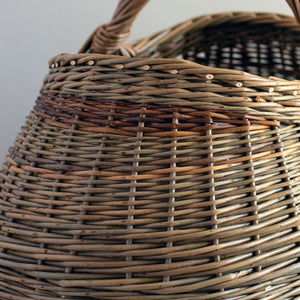 Woven willow basket with handle, handmade using various natural willow varieties to create coloured details.