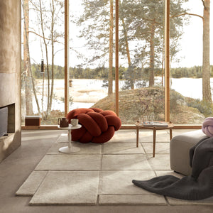 Living room with Design House Stockholm wool Basket rug in the centre, and a view of a natural landscape through the windows