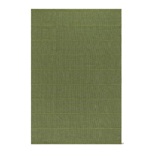 Kasthall’s Ängsmark Rug, designed by Ilse Crawford. The rug is olive green wool with a lime green stripe, and subtle white flecks running through the weave.