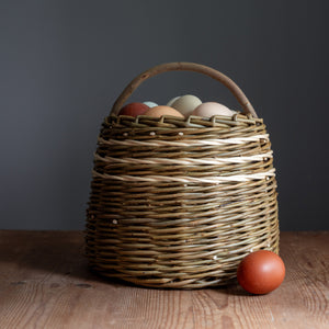 Handmade willow Forager basket with white lines pictured with eggs. Basket handmade by Rachel Bower, photo by Manna Reid.