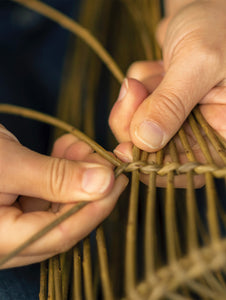 Natural home decor - Rachel Bower weaving a willow basket - willow is being twisted and woven by hand.
