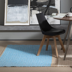 Recork Sugo Rug made from sustainable cork and linen pictured in contemporary dining room set. Rug is blue, beige and cream.