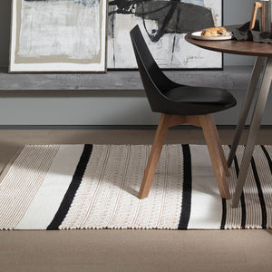 Patterned weave Recork Sugo Maria Rug made from sustainable cork in modern dining room space.
