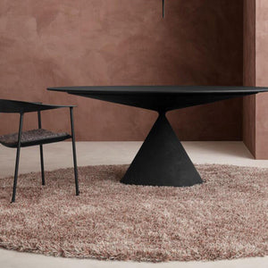 Kasthall’s Almond Blush Fogg rug is designed by Gunilla Lagerhem Ullberg.  The long pile Fogg rug has a variety of shades of blush pink creating a shimmering colour effect, full of lustre. The rug is under a round matt black dining table with matching chair. Walls are painted a textured terracotta pink. 