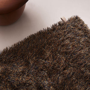 Close up of Kasthall’s Copper Blue Fogg rug. The variety of shades in the long linen pile creates a shimmering colour effect, full of lustre. You can imagine walking on this linen Fogg rug and it feeling super soft and springy underfoot and the appearance of the long linen fibres look almost windswept.