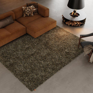 Kasthall’s Moss Rug is hand tufted in pure wool and linen. Designed by Gunilla Lagerhem Ullberg. This rug has a mix of long, natural linen fibres and shorter wool threads which create a uniquely full and lustrous pile. The rug is placed under a caramel-coloured sofa and next to a round open fire. 