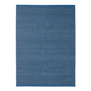 Textured blue rug with contrasting blue border at either end.