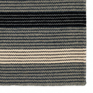 Close up view of the texture of the Fabula Living Fleur rug featuring stripes-within-stripes. The well-balanced pattern is woven in harmonious ash grey and black