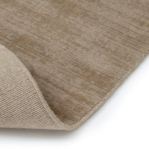 A close up image showing the front and back of the Fabula Living’s Beige Loke Rug, which  is hand loom woven in a single colour, the technique used soften's the pile and create an irregular pattern designed by Jens Landberg Schrøder