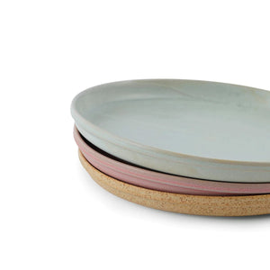 Julie Damhus' Toto Plates stacked together. Three coloured plates - mint, rose pink and honey brown decorated with speckled colour glazes.