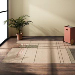 Tacto's Caminos Beige Rug, in a light room on a wooden floor, with a plant and cabinet placed near by - designed by Yonoh