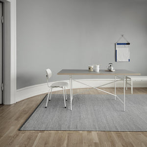 Fabula Living’s Charcoal/Off White Erica Rug in a light room sat on a wooden floor with a white desk and chair placed on top of the rug - designed by Lisbet Friis