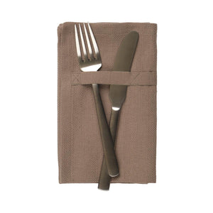 The Organic Company Clay Dinner Napkin is folded with a knife and fork placed on the napkin, and under the cloth tab. Made from 100% GOTS certified organic cotton and woven with a herringbone weave pattern.