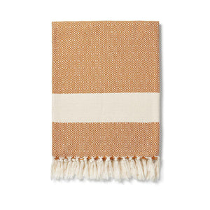 Damla tan organic cotton blanket by Lüks.  Traditionally handwoven with a diamond pattern and finished with a cream knotted fringe at each end