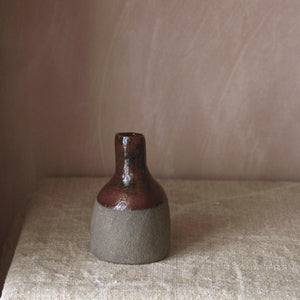 This handmade vase contrasts a rich chestnut brown glaze with a matt grey finish. This organic and rustic stoneware vase is glazed on the top half and inside.