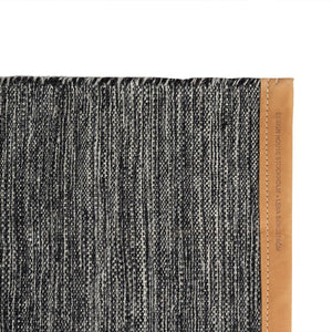 Design House Stockholm Dark Grey Björk Rug, designed by Lena Bergström. Flatweave wool rug with a speckled colour effect in the weave and leather edges, and brand details..