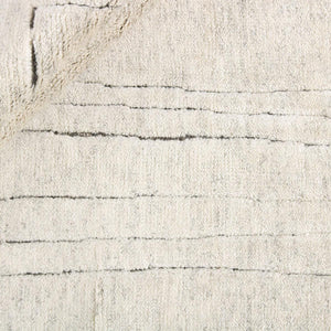 A close up look at Desert Natural Landscape Rug with abstract charcoal lines on a beige knotted rug - by Rezas