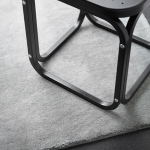 Fabula Living’s Grey Ask Rug with a dark side table sat on the rug - designed by Jens Landberg Schrøder