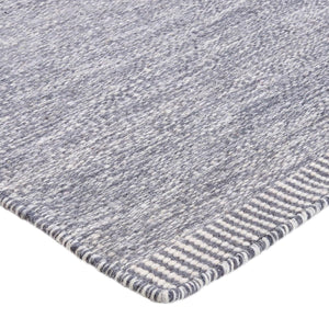 A close look at the weave pattern and texture of the Rezas' Grey Comfort Rug which has a two tone weave effect. The rug is finished with a simple striped border at the ends.