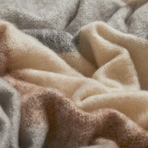 Owl Silare mohair throw blanket by Cushendale, features block stripes of chestnut, warm grey and cream. The blanket is shown scrunched up. 